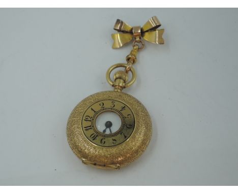 A lady's Victorian yellow metal half hunter top wound pocket watch stamped 18K of small form, having Roman numeral dial to wh