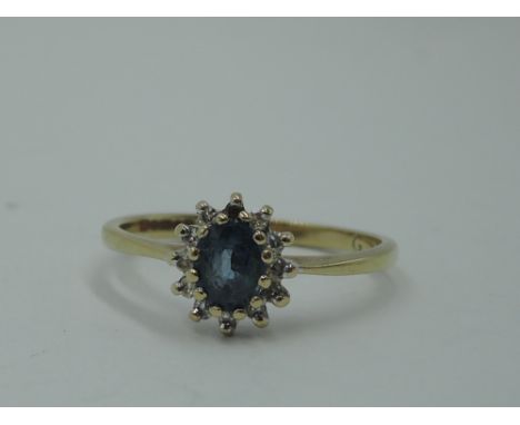 A tanzanite and diamond cluster ring of dainty form to knife blade shoulders on a 9ct gold loop, size L/M &amp; 1.5g, (1 ston