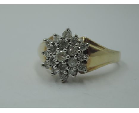 A lady's dress ring having a diamond chip triple cluster in a stepped mount to shaped shoulders on a 9ct gold loop,  size O