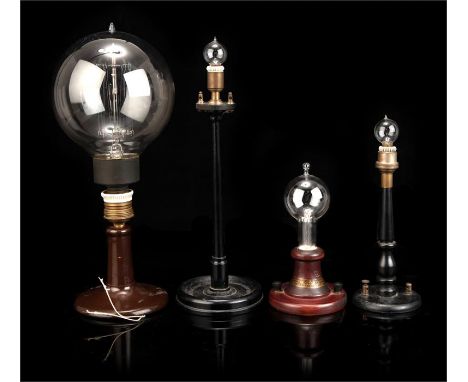 Four Early Electric Lamps,mounted on stands, including a 1929 reproduction of the first Edison lamp, with a label for 'Approx