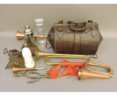 A collection of brass and copper hunting horns, two brass stirrups and spurs, and a South American style Gladstone
