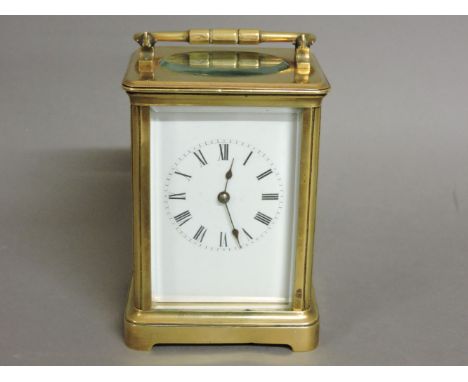 A brass carriage clock, with an enamelled face, and Roman numerals, 15cm high