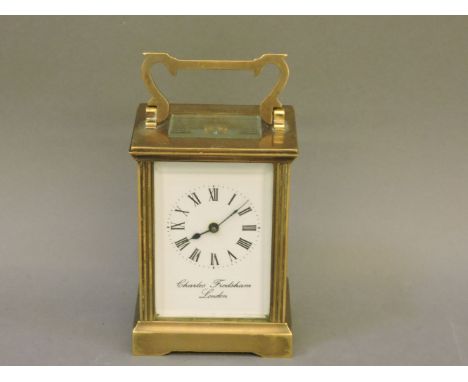 A 20th century gilt cased carriage clock, signed Charles Frodsham London, with white enamelled dial, bevelled glass face on b