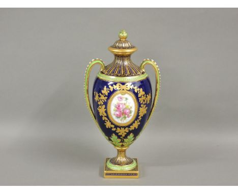 A Copeland Spode porcelain two handled urn vase with cover, painted with flower panels, one signed, 27cm high