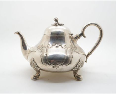 A danish silver teapot, of squat pear form with engraved rococo decoration with blank cartouches, with scrolling handle and f