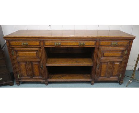 A Victorian oak sideboard with three drawers above open shelves flanked by panel doors, 100cm high x 214cm wide x 58cm deep C