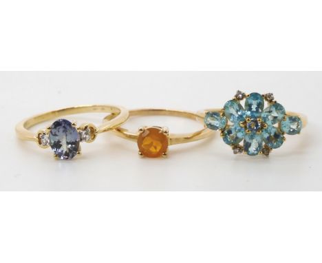 Three gem set rings, to include fire opal, size L1/2, an apatite and diamond accent cluster size L, and a blue and clear gem 