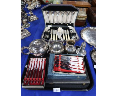 A quantity of EPNS including a three piece tea service with double scroll handles and engraved floral decoration, cased sets 