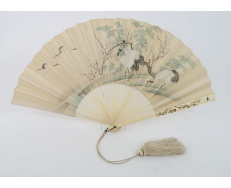 A JAPANESE OGI FAN the&nbsp; double parchment leaf painted in watercolours with storks amongst blossoms and trees, the revers