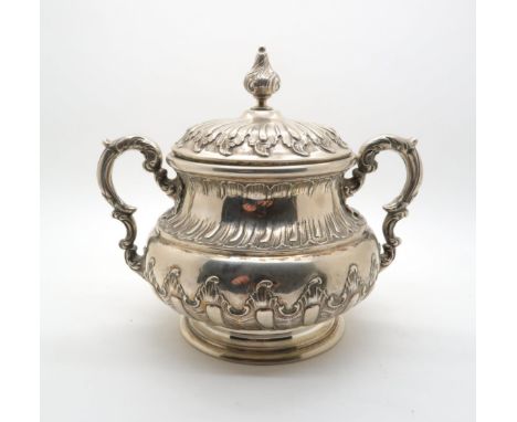 A continental twin handled white metal sugar bowl, of cauldron form with repousse rocaille decoration, with scrolling handles