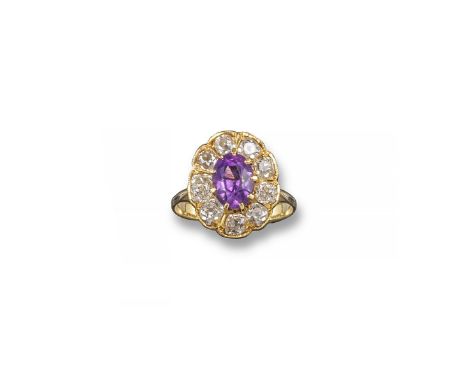 Amethyst and diamond cluster ring. The oval-shaped amethyst is set within a surround of nine cushion-shaped diamonds in yello