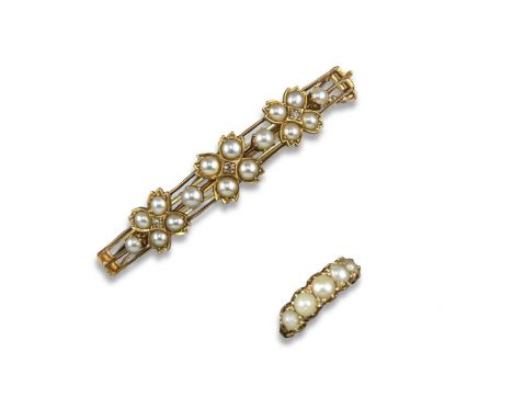 An Edwardian gold hinged bangle with three floral clusters each centred with a diamond with half pearls and a gold half hoop,