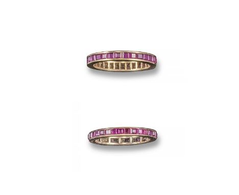 A ruby-set pink gold full-circle eternity ring. Set with calibre-cut rubies with scroll-engraved shoulders. Size M½. And anot