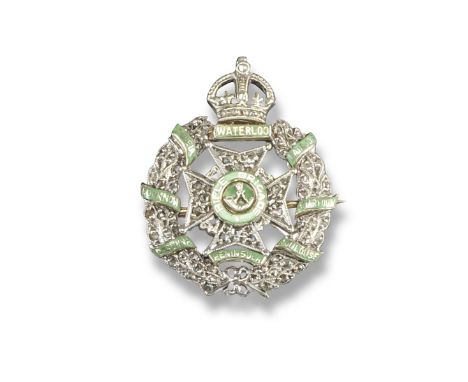 A Regimental brooch for The King's Royal Rifle Corps, millegrain set with diamonds and applied with green enamel. 2.3cm wide.