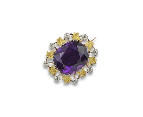 An early 20th century amethyst and diamond-set gold brooch, the cushion-shaped amethyst is set within a surround of platinum 