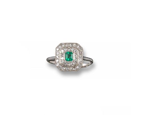 An Edwardian emerald and diamond cluster ring, centred with an emerald-cut emerald set within a double millegrain surround of