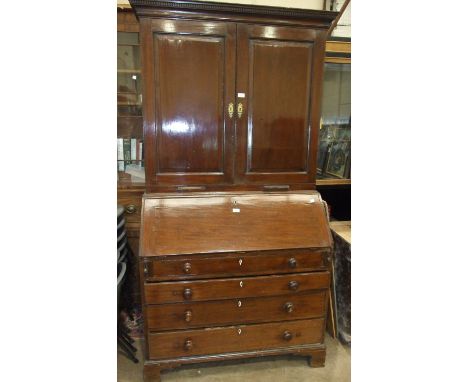 A Georgian mahogany bureau/bookcase, with dentil cornice above a pair of panelled doors with fitted interior and candle holde