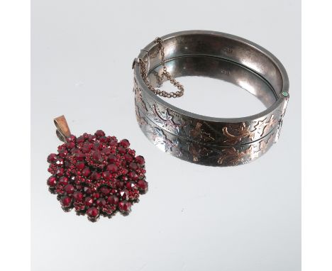 A Bohemian garnet cluster pendant, together with a silver hinged bangle, with applied decoration in the antique style, Cheste