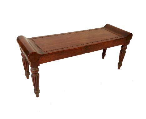 An early 19th century mahogany window seat or stool, with scroll ends and button push moulding, raised on reeded legs, width 