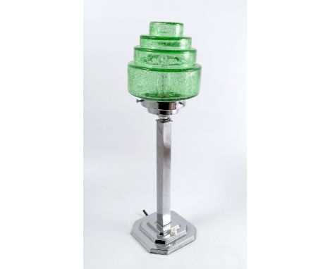 An Art Deco table lamp, the stepped circular green cracked ice shade supported on a chrome rectangular column to a stepped sq