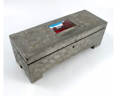 A rectangular pewter Art Nouveau box, with embossed decoration of flowers, having an enamel rectangular panel of stylistic la