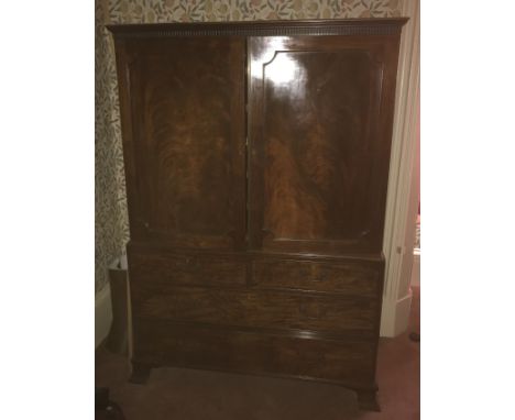 A 19th century mahogany linen press, having two panelled doors opening to reveal six slide out trays, fitted with two short a