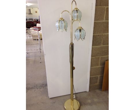 A brass standard lamp with 3 glass flower head shades.