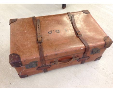 A vintage large brown trunk with leather corners and straps