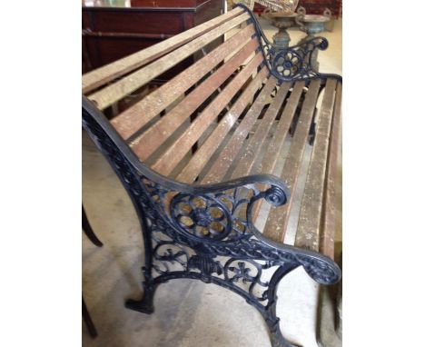 A garden bench with black cast iron ends and wooden slats, 127cm wide.