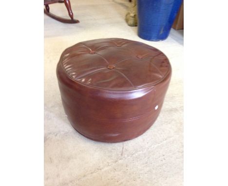 A vintage brown leather pouffe.