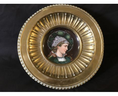 A religious brass tazza with porcelain portrait of female saint to centre.