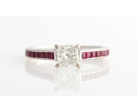 A hallmarked 18ct white gold, diamond and ruby ring, set with a princess cut diamond measuring approx. 0.50ct, shoulders chan