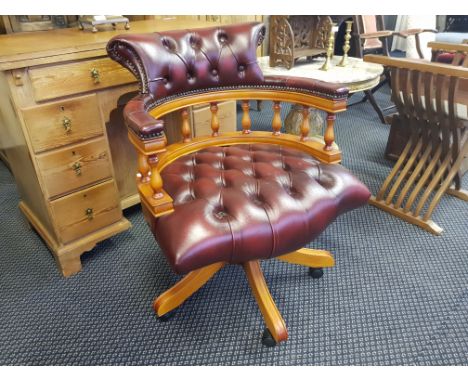 A reproduction swivel office elbow chair in leather upholstery with button back and seat.