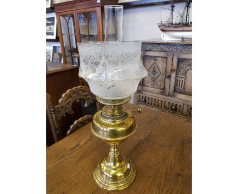A brass oil lamp with etched glass shade and funnel.