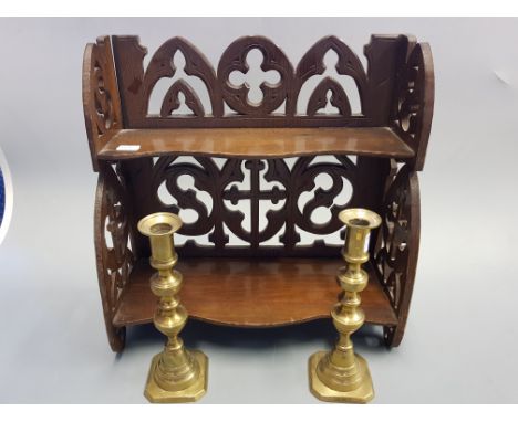 A two tier Gothic Style shelf unit and pair of 19th century brass candlesticks.