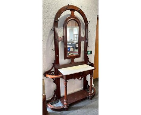 A VICTORIAN MAHOGANY HALL STAND  centred with an arched shaped mirror, flanked by ten hat and coat hooks, the marble top with