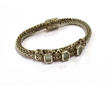 SILVER &amp; AQUAMARINE BRACELET Three octagonal step cut aquamarines, estimated to total 2.9 carats, collet set onto a scrol
