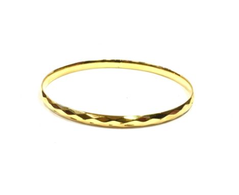 9CT GOLD METAL CORE BANGLE 8cm diameter, 5.7mm wide, with faceted decoration to exterior, smooth slightly convex interior, st