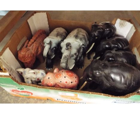 A collection of ceramic and ebony carved elephants
