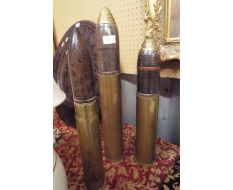 A group of three WWI & WWII deactivated munition shells two with brass timer heads