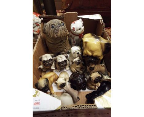 A collection of ceramic and wooden models of pug dogs