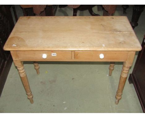 A 19th century stripped pine side table, fitted with two shallow frieze drawers raised on ring turned and tapered supports 