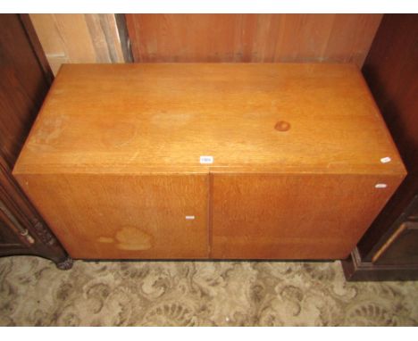 An art deco style light oak veneered low cupboard, enclosed by a pair of doors, the interior fitted with a side by side arran