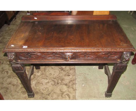 A Victorian Gothic oak side/hall table of rectangular form with carved border over a frieze drawer with green man cup handle 