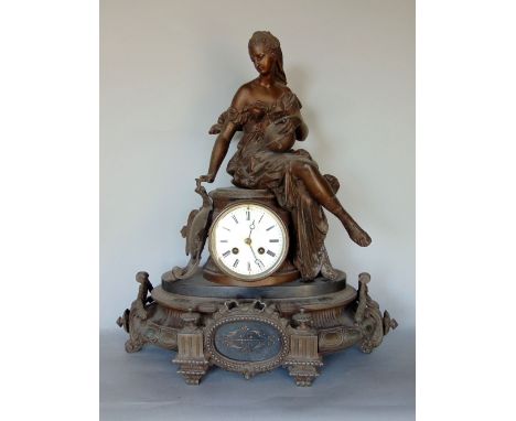 Late 19th century French spelter figural mantle clock, the two train 4 inch enamel dial mounted with a figure of a seated fem