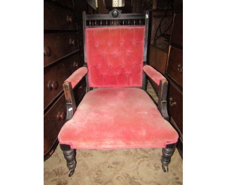 A late Victorian drawing room chair with pink ground upholstered seat, button back and arms within an ebonised frame with mou