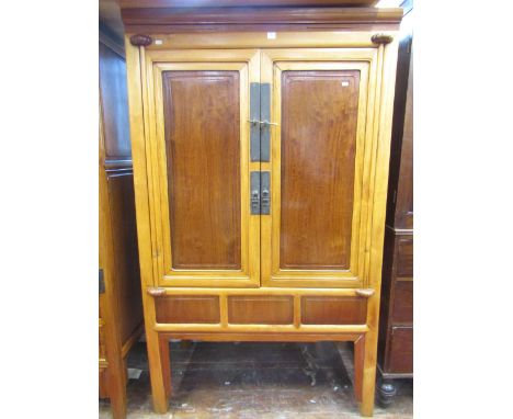 A Chinese pine, fruitwood and walnut cabinet, enclosed by two panelled doors, the interior fitted with an arrangement of draw