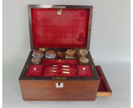 19th century rosewood dressing box, the hinged lid enclosing an interior fitted with various glass bottles and ivory manicure