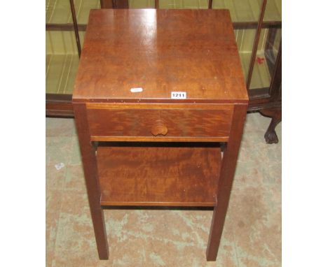 A Heal's two tier lamp table of square cut form fitted with a frieze drawer with inset circular ivorine label