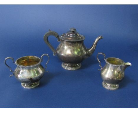 An early 20th century three piece silver baluster tea service comprising tea pot, milk jug and twin handled sucrier, all with